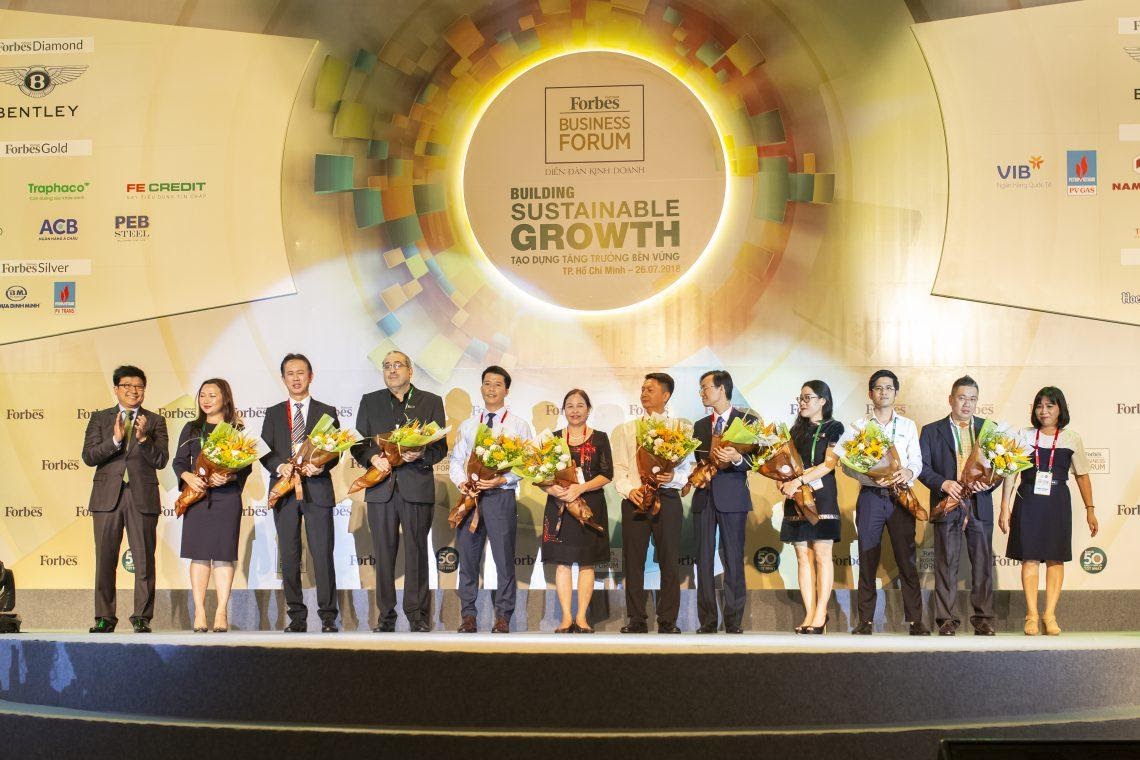 Photo of businesses’ representatives receiving honorary flowers at the Forbes 2018 business forum