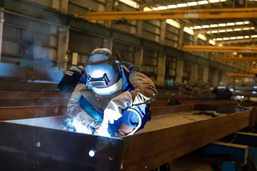 Fabrikasi struktur baja dan pelat baja melibatkan proses pembuatan komponen baja seperti balok, kolom, dan rafter sesuai dengan desain di pabrik